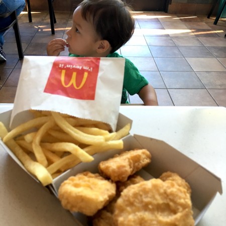 Cute baby eating chicken nuggets at McDonald's