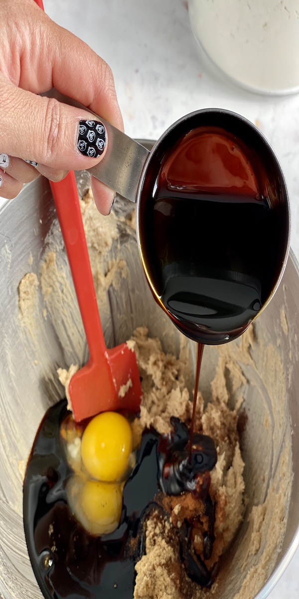 pouring molasses into a mixing bowl