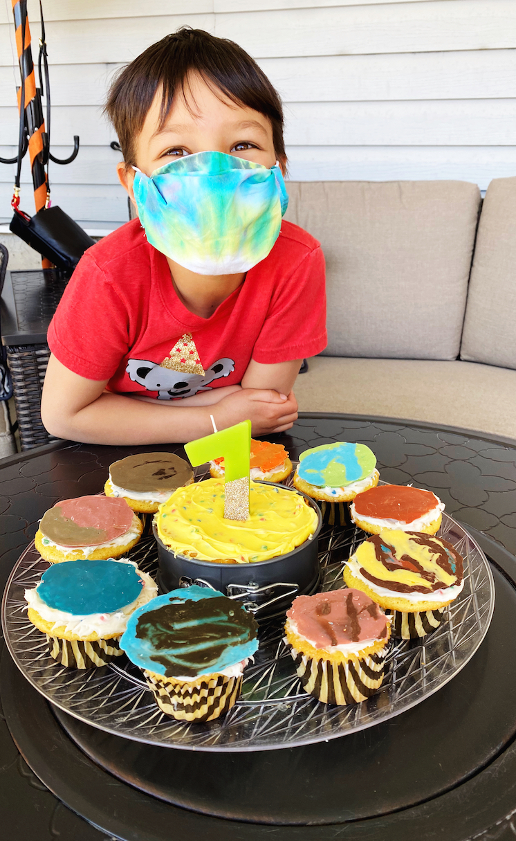 boy in mask with solar system cupcakes