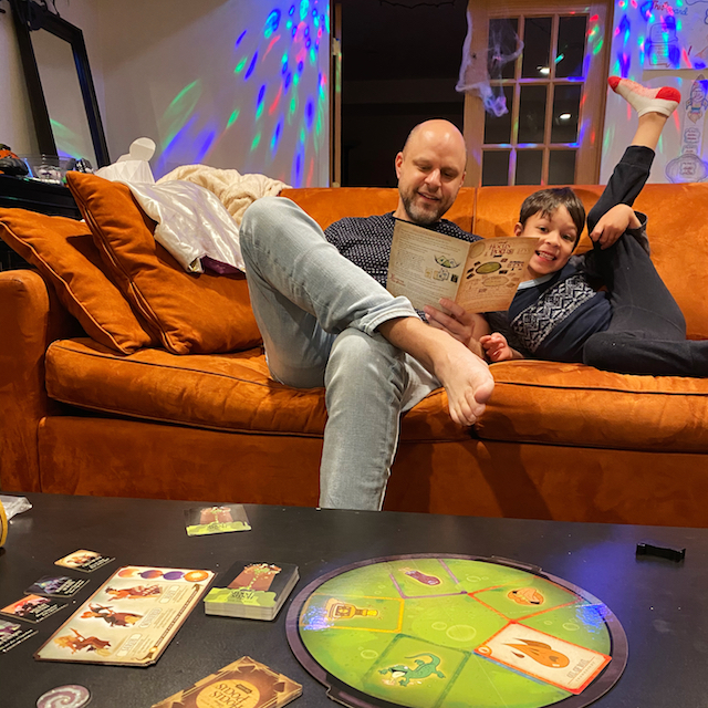 man and son on couch playing hocus pocus board game