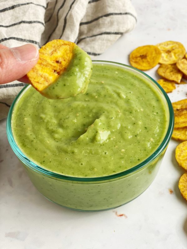 plantian chip being dipped into tomatillo avocado salsa