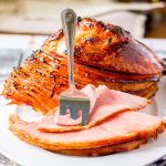 slice cut ham with brown sugar glaze and fork