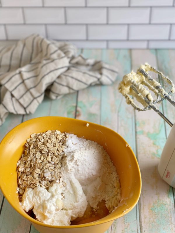 bowl of oatmeal banana bread ingredients with hand mixer
