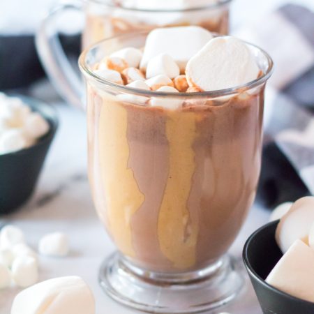 glass mug with peanut butter drizzle and hot chocolate with marshmallows