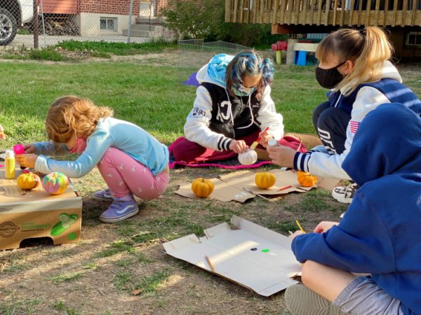 kids painting pumpkins outside