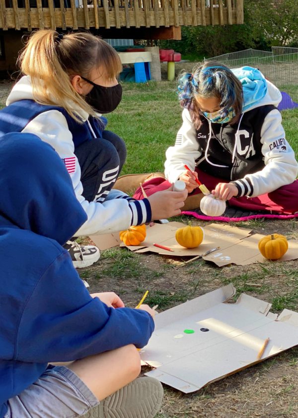 girls painting mini pumpkins