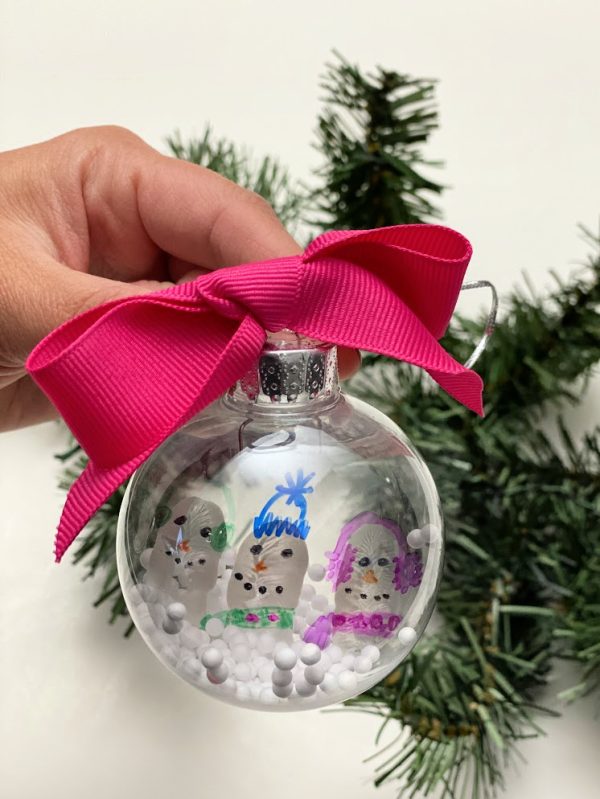 snowman ornament with floating snow being held