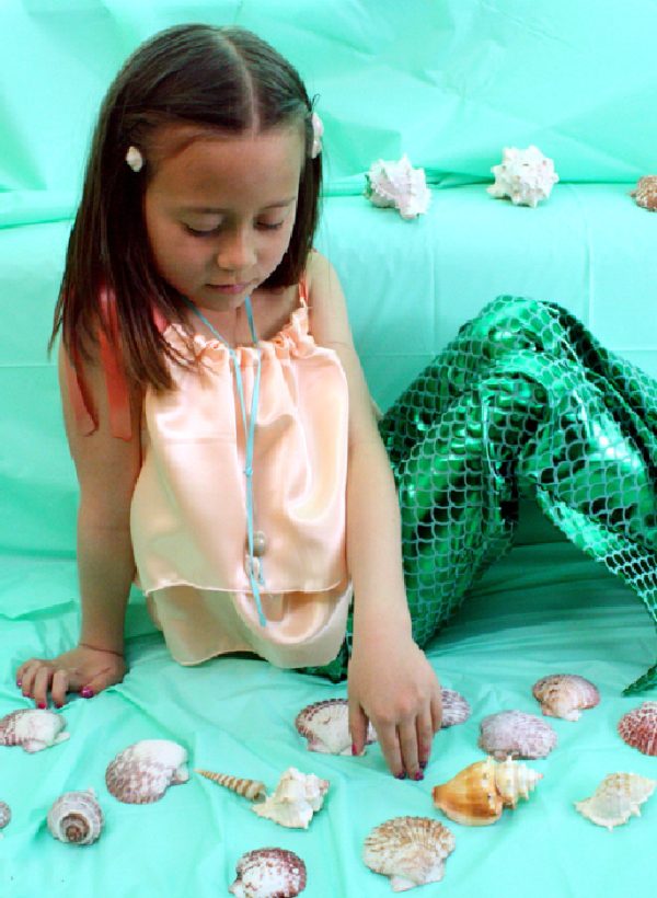 little girl dressed as a mermaid with shells